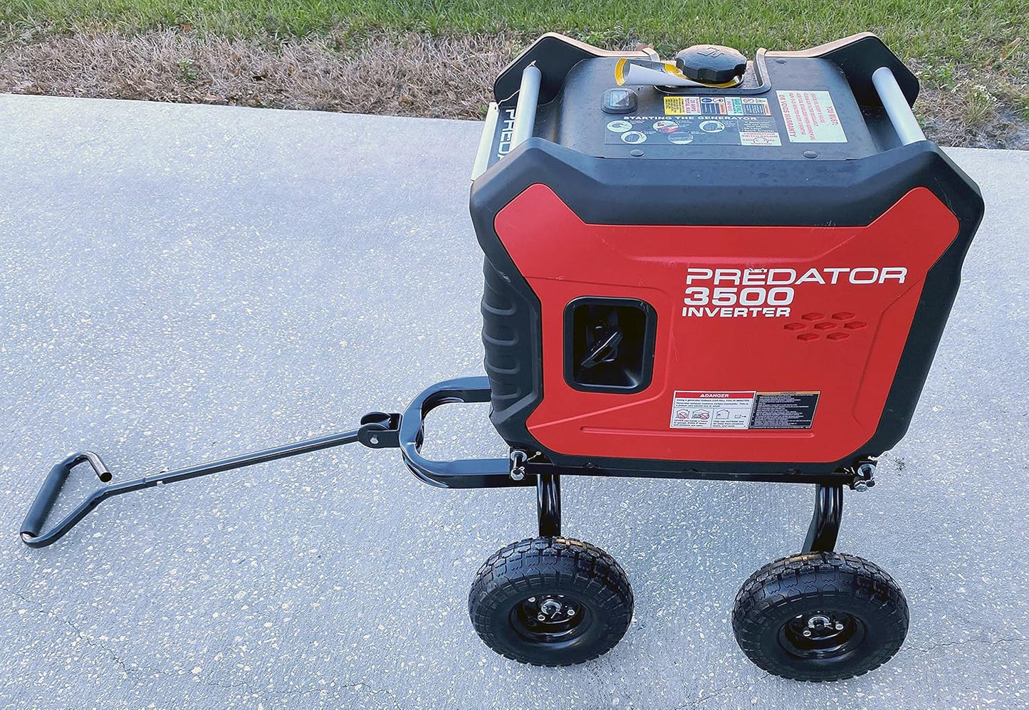 Red and black inverter generator on a concrete surface.